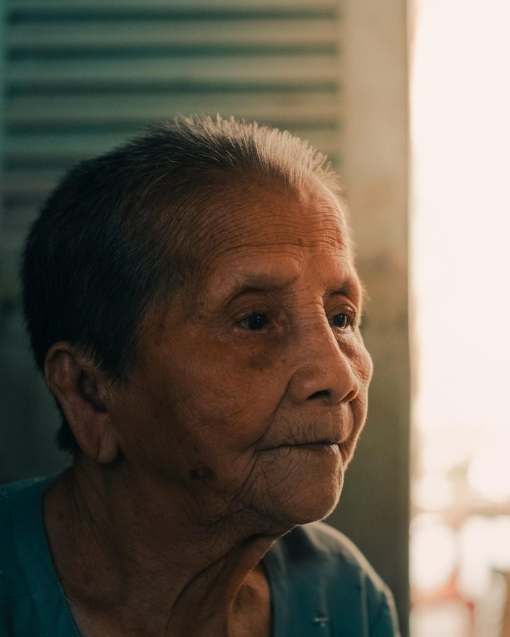 Un hombre mayor mira hacia la ventana, con la luz de la mañana